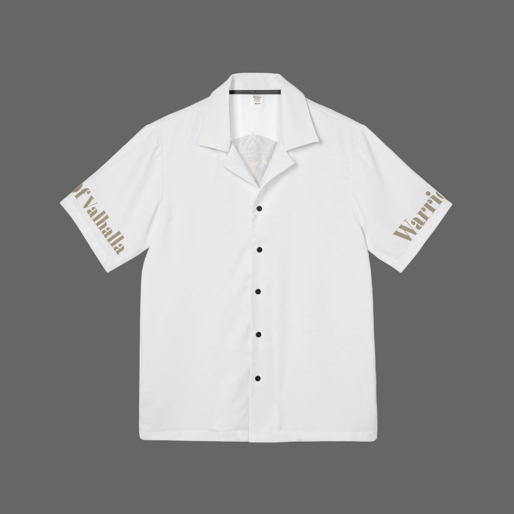 A white short-sleeve camp collar button-up shirt with black buttons, featuring 'Valhalla' printed in gold on the right sleeve and 'Warri' in gold on the left sleeve, displayed flat against a white background.